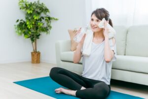 エクササイズをしながら水分を取る女性