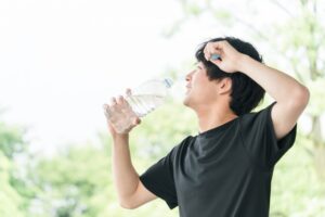 運動して汗をかいて水分補給をする男性