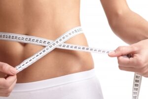 ダイエット後にお腹周りを測る女性