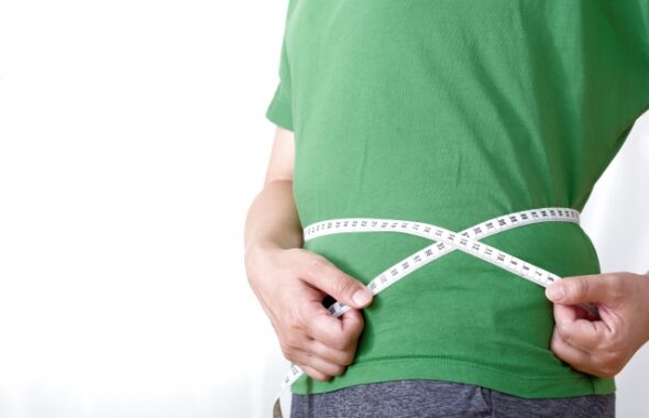 ダイエット効果の確認でウエストを図る男性