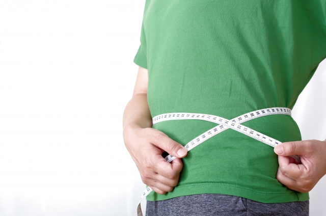 ダイエット効果の確認でウエストを図る男性