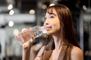 トレーニングジムで水を飲む女性