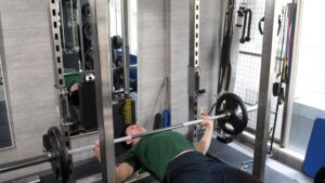 1人でベンチプレスをしている男性