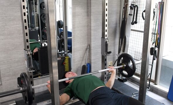 ジムでベンチプレスをしているトレーニーのイラスト