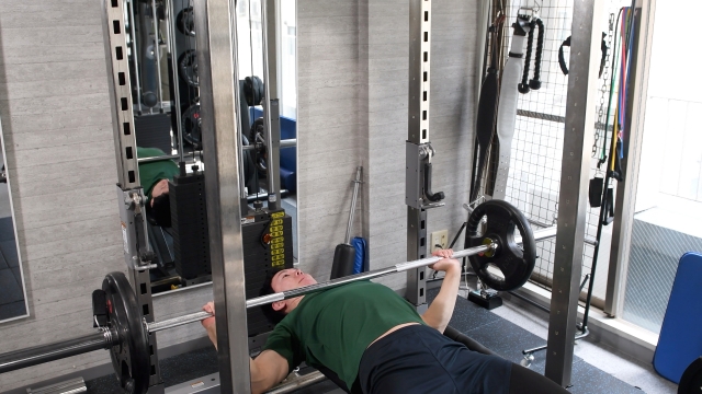 ジムでベンチプレスをしているトレーニーのイラスト