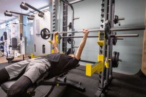 ボディメイクのためにベンチプレスをしている男性のイラスト