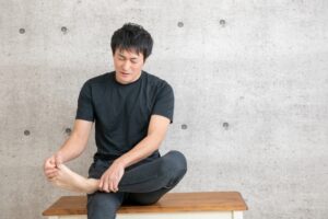足首の柔軟性を上げるためにストレッチをしている男性