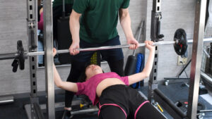 パーソナルトレーニングジムでパーソナルトレーニングを受ける女性