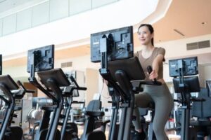 ジムでバイクを漕ぐ女性のイラスト