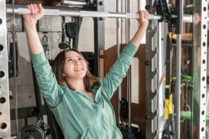 ダイエットのためにスポーツジムでトレーニングをしている女性