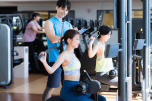 トレーナーの指導を受けながらトレーニングをしているイラスト